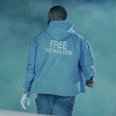 a man wearing a blue jacket with the words free the man dem printed on it