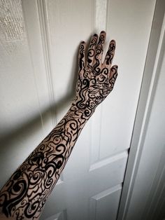 a person's arm with black and white tattoos on it next to a door