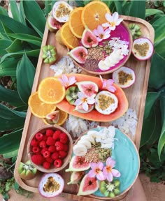 there are many different fruits and vegetables on the tray, including oranges, raspberries, kiwis, and watermelon