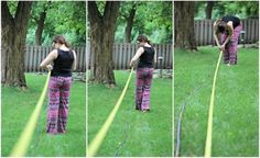 the woman is using a garden hose in her yard