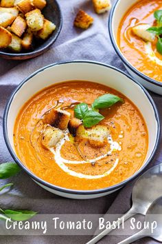 two bowls of creamy tomato basil soup with croutons