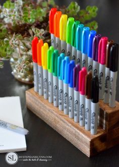 a wooden stand with many different colored pens