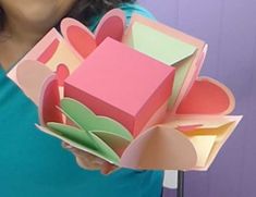 a woman is holding some colorful boxes in her hands