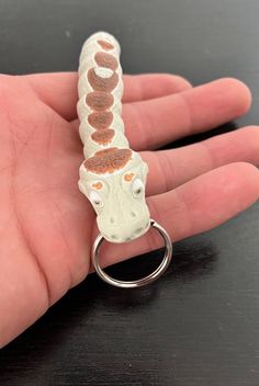 a small giraffe keychain sitting on top of a person's hand