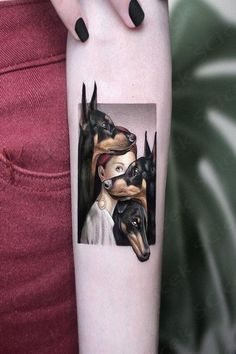 a woman's arm with three dogs on it