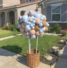 a basket filled with balloons in front of a house