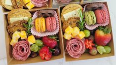 four boxes filled with different types of sandwiches and fruit on top of each box,