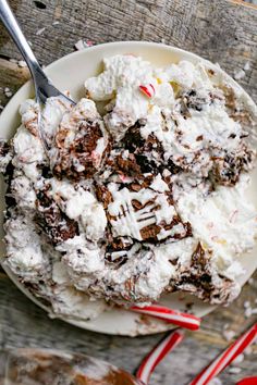 a white plate topped with cake and ice cream next to two red striped candy canes