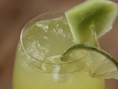 a close up of a drink with a slice of lime on the rim