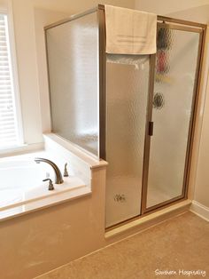 a bathroom with a walk in shower next to a bath tub