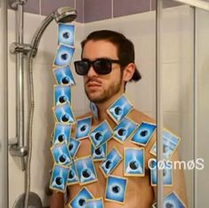 a man with sunglasses on his head is standing in front of a shower full of pictures