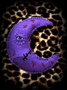 the letter c is made out of purple yarn with crosses on it and eyes are drawn in