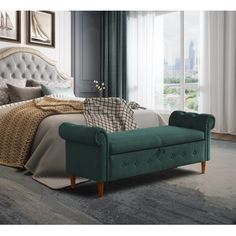 a bedroom with a large bed and green velvet upholstered bench in front of the window