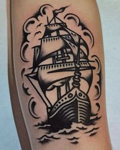 a black and white ship tattoo on the arm