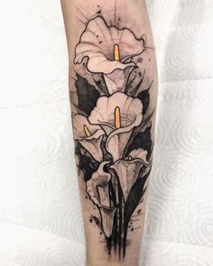 a woman's leg with a flower tattoo on the side of her body and two candles