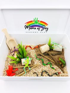 a white box filled with sand and plants