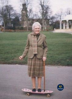 an old woman is standing on a skateboard in the street with her cane and coat