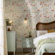 a bedroom with floral wallpaper and an old - fashioned dresser in the foreground