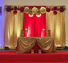 a red and gold stage set up for a wedding