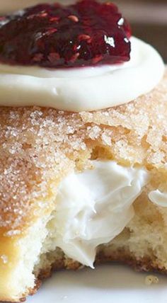 a close up of a pastry on a plate with powdered sugar and jelly in the middle