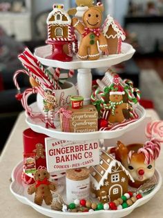 a three tiered tray filled with gingerbread cookies and candies