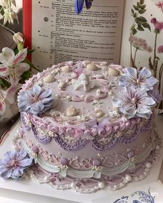 there is a cake that has been decorated with flowers and seashells on it