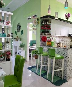 a kitchen filled with lots of green chairs