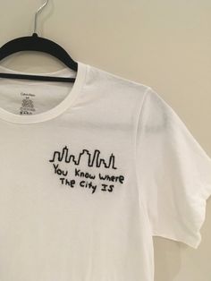 a white t - shirt that says, you know where the city is