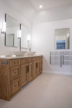 a bathroom with two sinks and mirrors on the wall