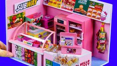 a pink toy store with lots of food and candy in it's display case