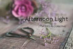 a pair of scissors sitting on top of a wooden table next to flowers and the words afternoon light