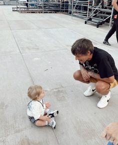 a man kneeling down next to a small child on top of a cement floor with yellow halos around his head