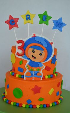 a birthday cake decorated with an orange and blue theme