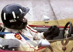 a person in a race car with a helmet and gloves on, holding the steering wheel