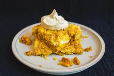 a white plate topped with two pieces of cake next to whipped cream on top of it