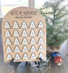 a wooden calendar sitting on top of a table next to a christmas tree and other decorations