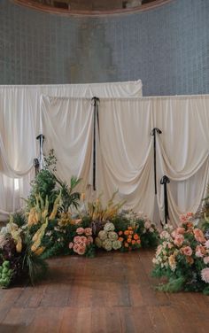 an arrangement of flowers and greenery on a wooden floor