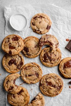 chocolate chip cookies on parchment paper with one broken in half and the other filled with them