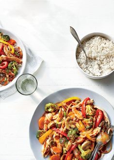 two bowls filled with rice and vegetables next to each other on a white table top