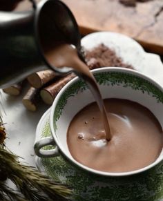 a cup of hot chocolate being poured into it