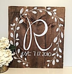 a wooden sign with the number nine painted on it and flowers in vase next to it