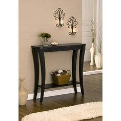 a black table sitting on top of a hard wood floor next to a white rug