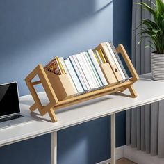 a laptop computer sitting on top of a wooden book shelf next to a bookshelf