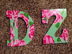 the letters are made out of paper and have pink flowers on them with green trim