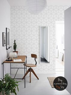 a room with a desk, chair and potted plant on the table in front of it