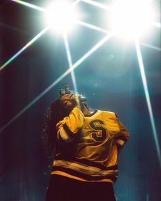 a woman in yellow jersey singing on stage