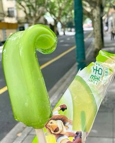 an ice lolly popsicle on the side of the road with cartoon characters painted on it