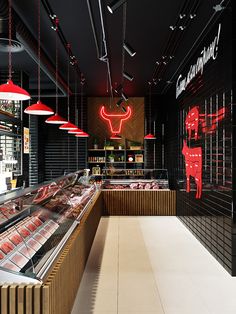 an empty meat shop with neon lights hanging from the ceiling