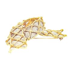 A fine Mid-Century Modern brooch.  In 18 karat yellow & white gold.  By Cartier.  In the form of a ribbon or folded scarf.  With yellow gold lattice above a worked white gold background.  Marked to the interior Cartier / 18K / and with a stamped serial number.  Simply wonderful Cartier design!  Date: Mid-20th Century  Overall Condition: It is in overall good, as-pictured, used estate condition with some fine & light surface scratches and other signs of expected light wear consistent with age.  Fineness: Marked 18k for gold fineness.  Marks: Marked to the reverse 18K / Cartier / faintly stamped serial no. marks.  Measurements: Height: ca. 40mm Width: ca. 68mm Depth: ca. 20mm  Weight: ca. 29.2 g  Please see our other related items. Luxury Gold Brooches With Intricate Design, Modern Brooch, Ribbon Brooch, Gold Background, Georg Jensen, Modern Branding, Lattice, Cartier, Yellow White