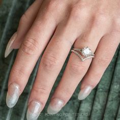 a woman's hand with two engagement rings on her left and the middle finger